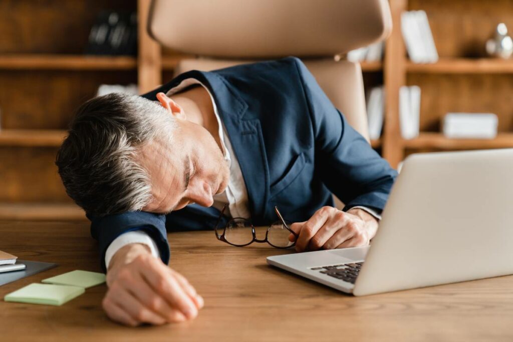 man with insomnia sleeping during work